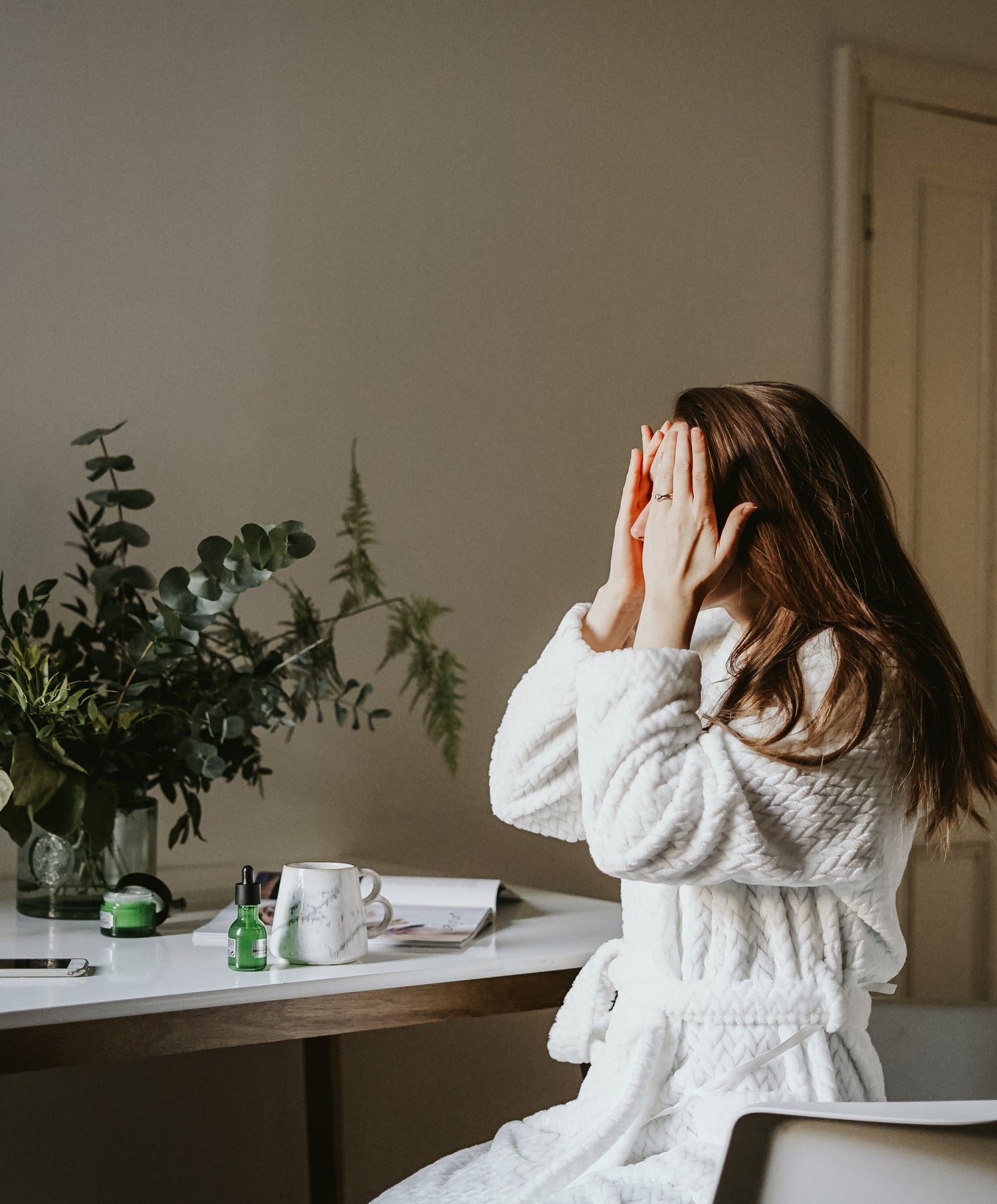女性がスキンケアをしている写真　ちょっと悩んでいる