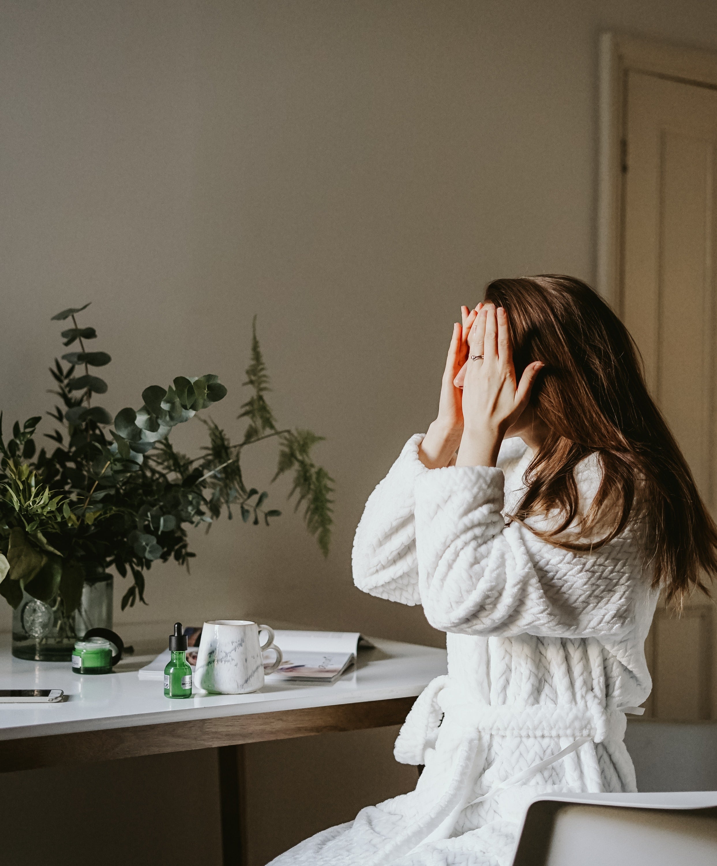 女性がスキンケアをしている写真　ちょっと悩んでいる